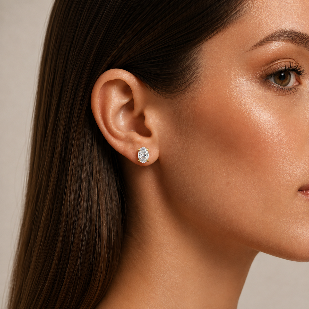 Oval-Cut Diamond Stud Earrings: model wearing an oval-cut diamond stud earring.