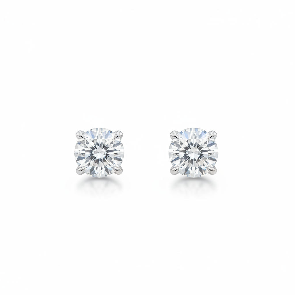 Pair of round brilliant diamond stud earrings in white metal, front view.