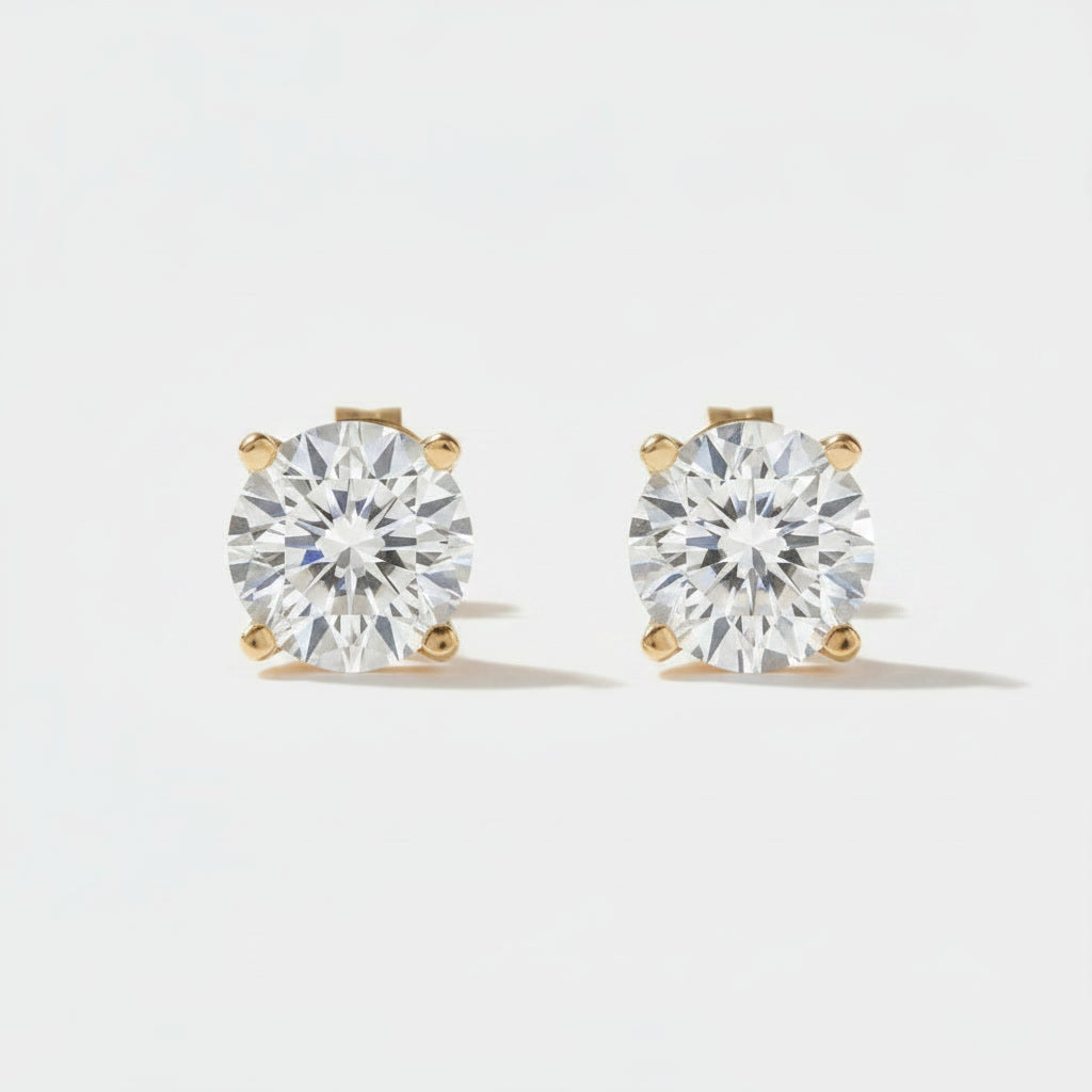 Round-Cut Diamond Stud Earrings: pair of round diamond stud earrings with yellow gold prongs, front view.