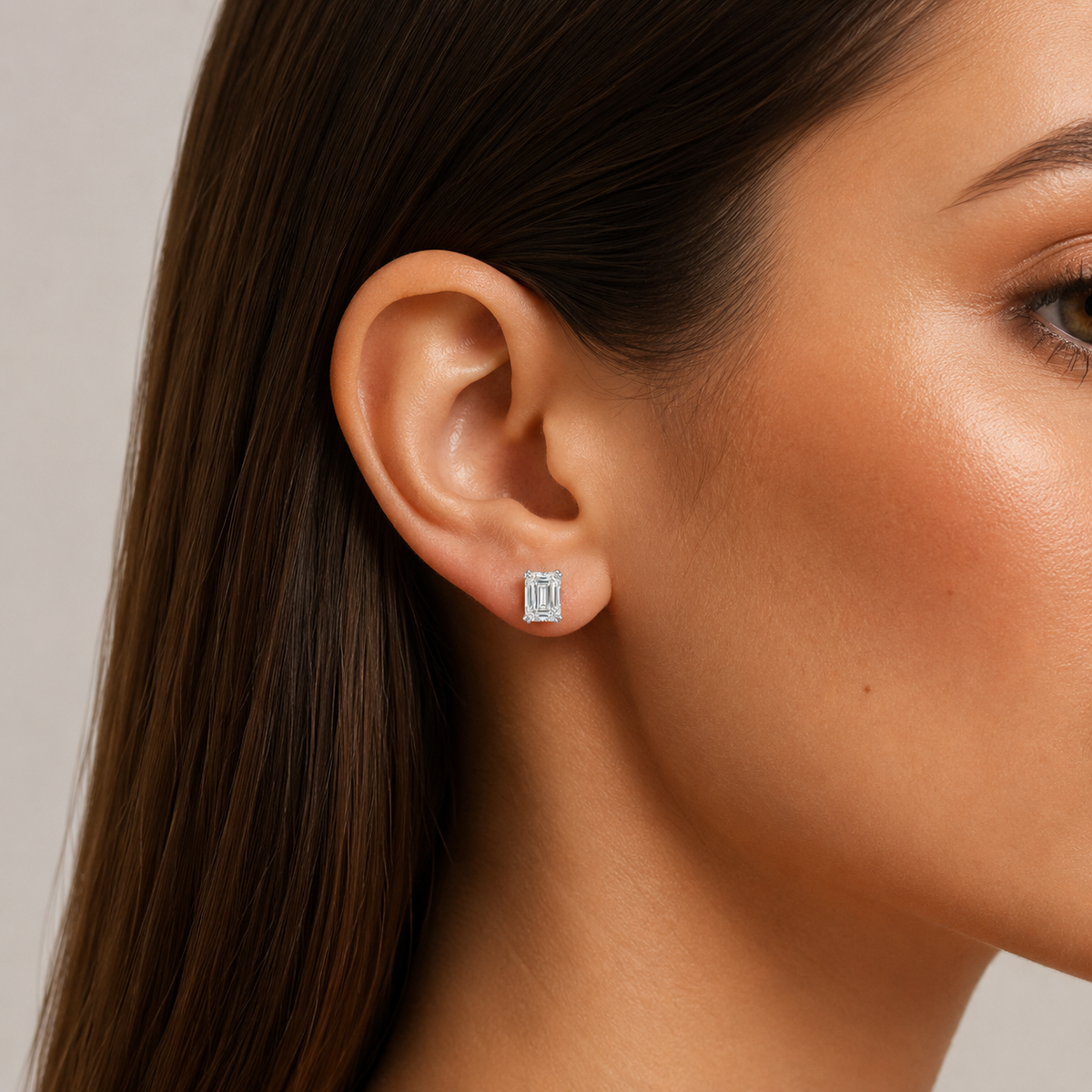 Emerald-Cut Diamond Stud Earrings: model wearing an emerald-cut diamond stud earring.