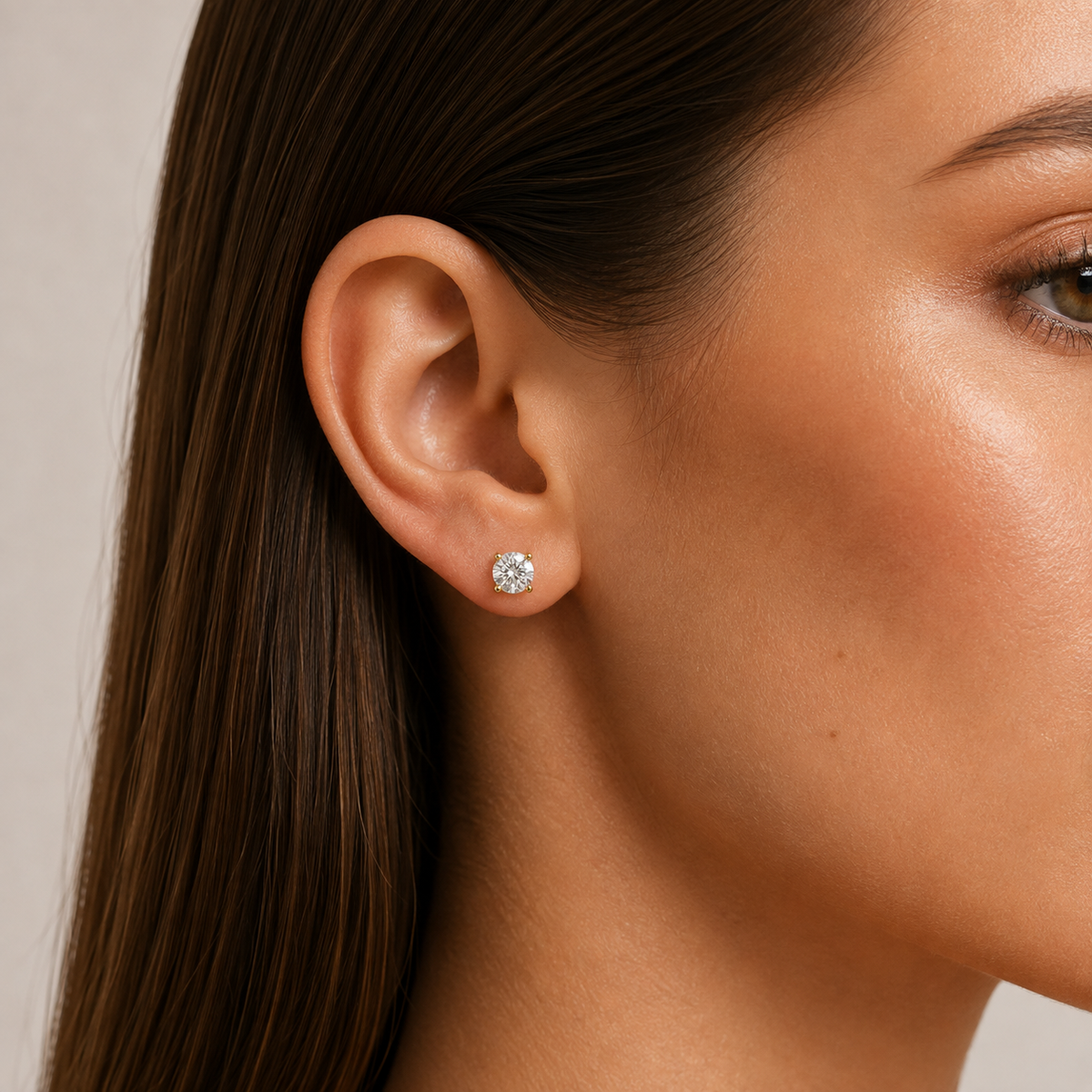 Round-Cut Diamond Stud Earrings: model wearing a round diamond stud earring.